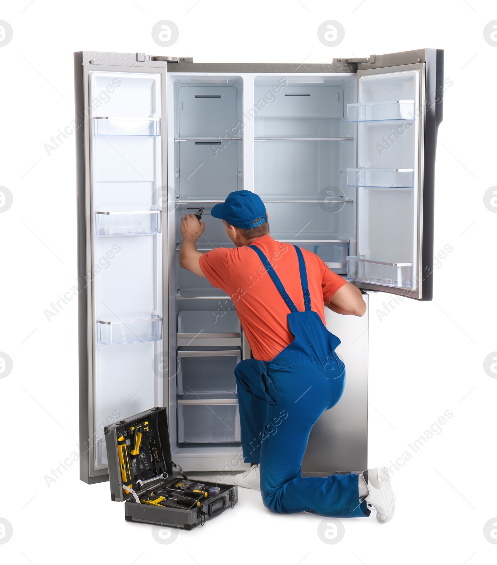 Photo of Male technician repairing refrigerator on white background