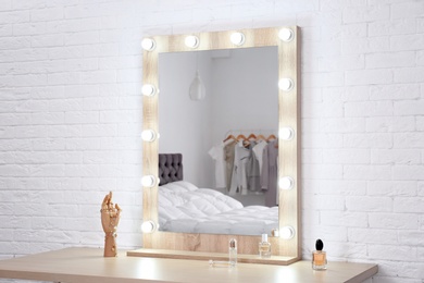 Makeup mirror on table near white wall in dressing room