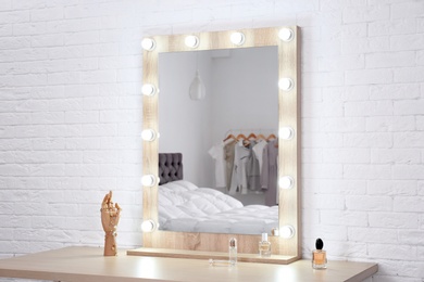 Photo of Makeup mirror on table near white wall in dressing room