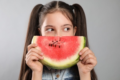 Photo of Cute little girl with watermelon on grey background