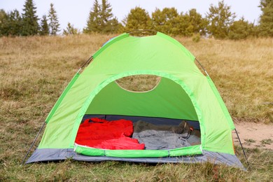 Photo of Sleeping bags in camping tent on green grass outdoors