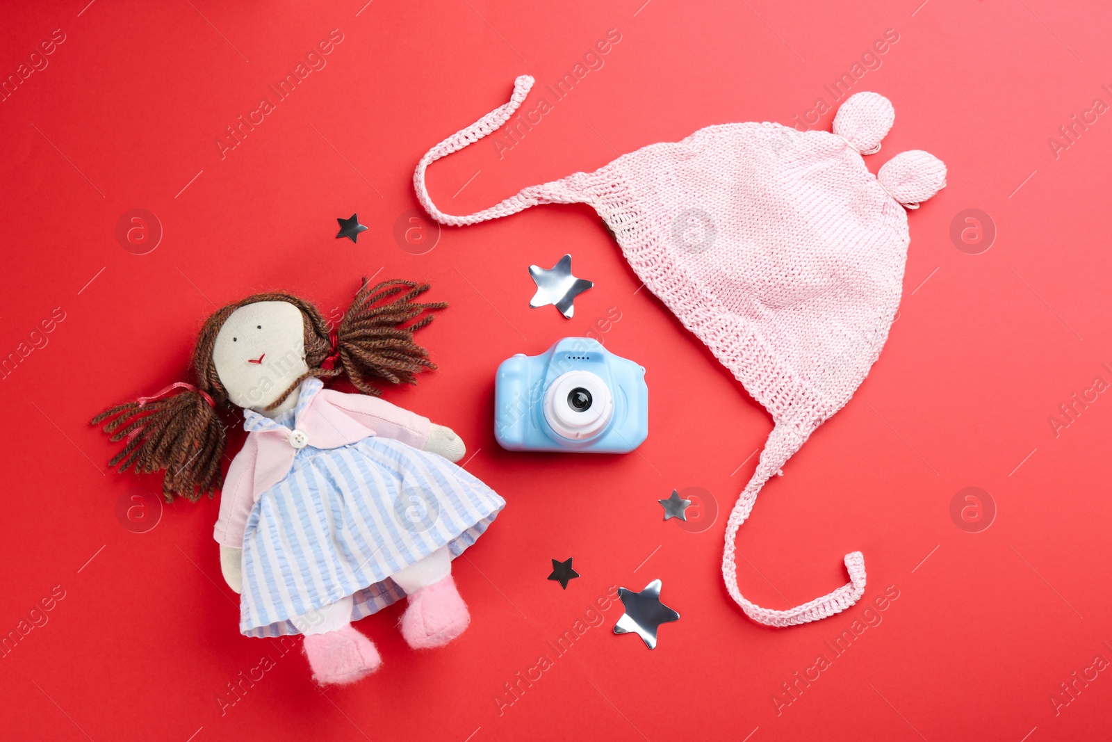 Photo of Flat lay composition with little photographer's toy camera on red background