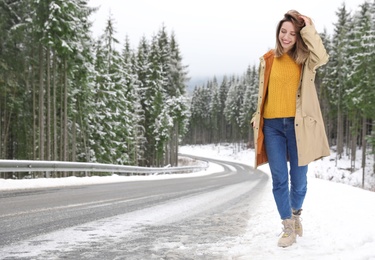 Photo of Young woman walking near snowy forest. Winter vacation