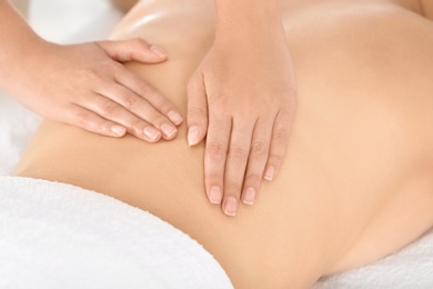 Relaxed woman receiving back massage in wellness center