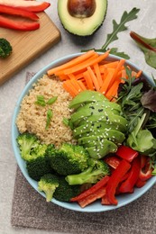 Delicious vegan bowl with bell peppers, avocados and broccoli on grey table, flat lay