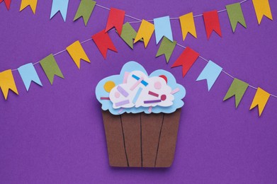 Birthday party. Paper cupcake and bunting flags on purple background, flat lay