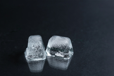 Ice cubes on wet black surface, closeup