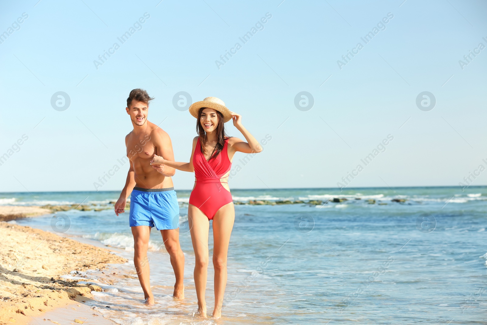 Photo of Happy young couple having fun at beach on sunny day