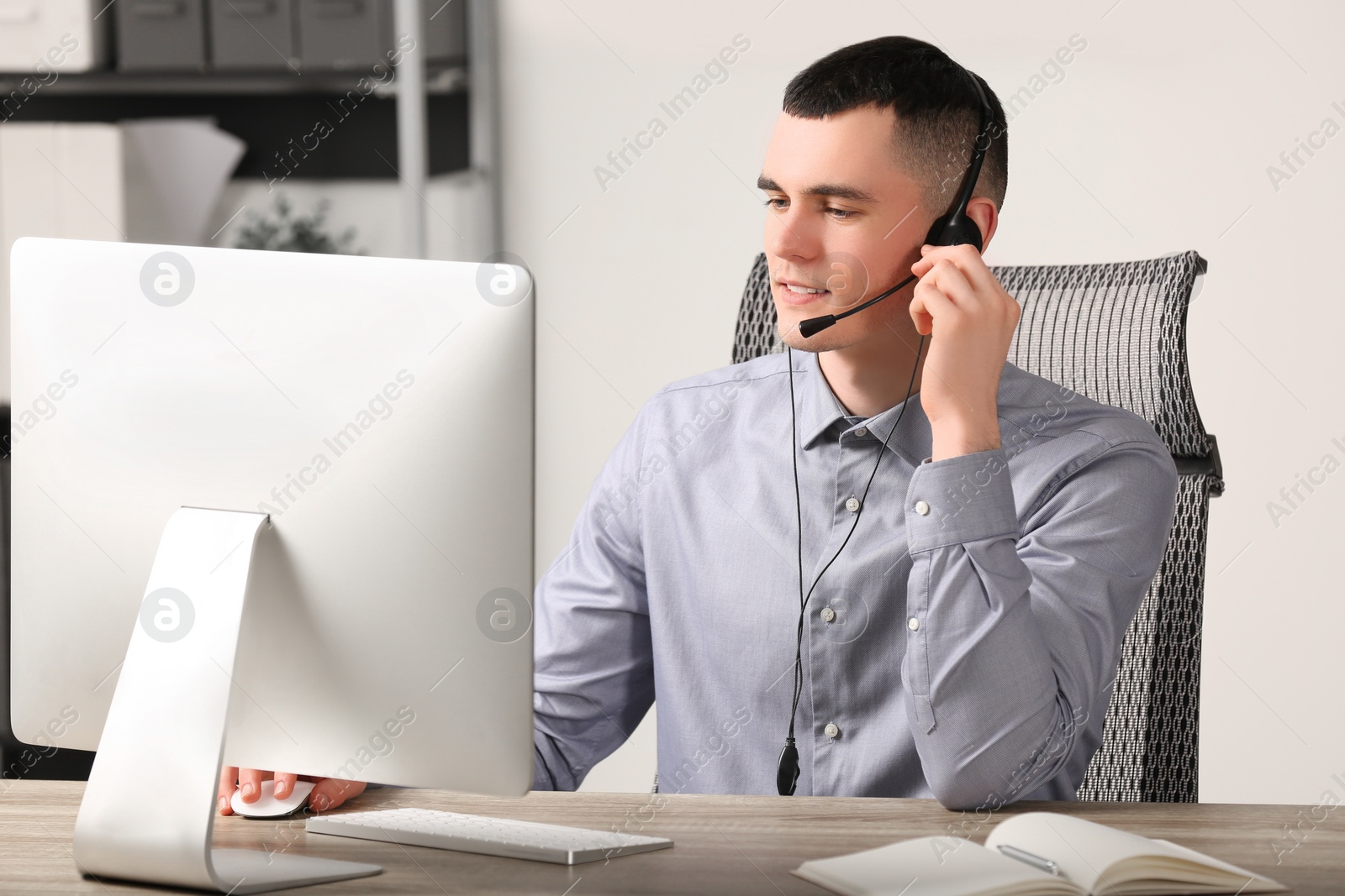 Photo of Hotline operator with headset working in office