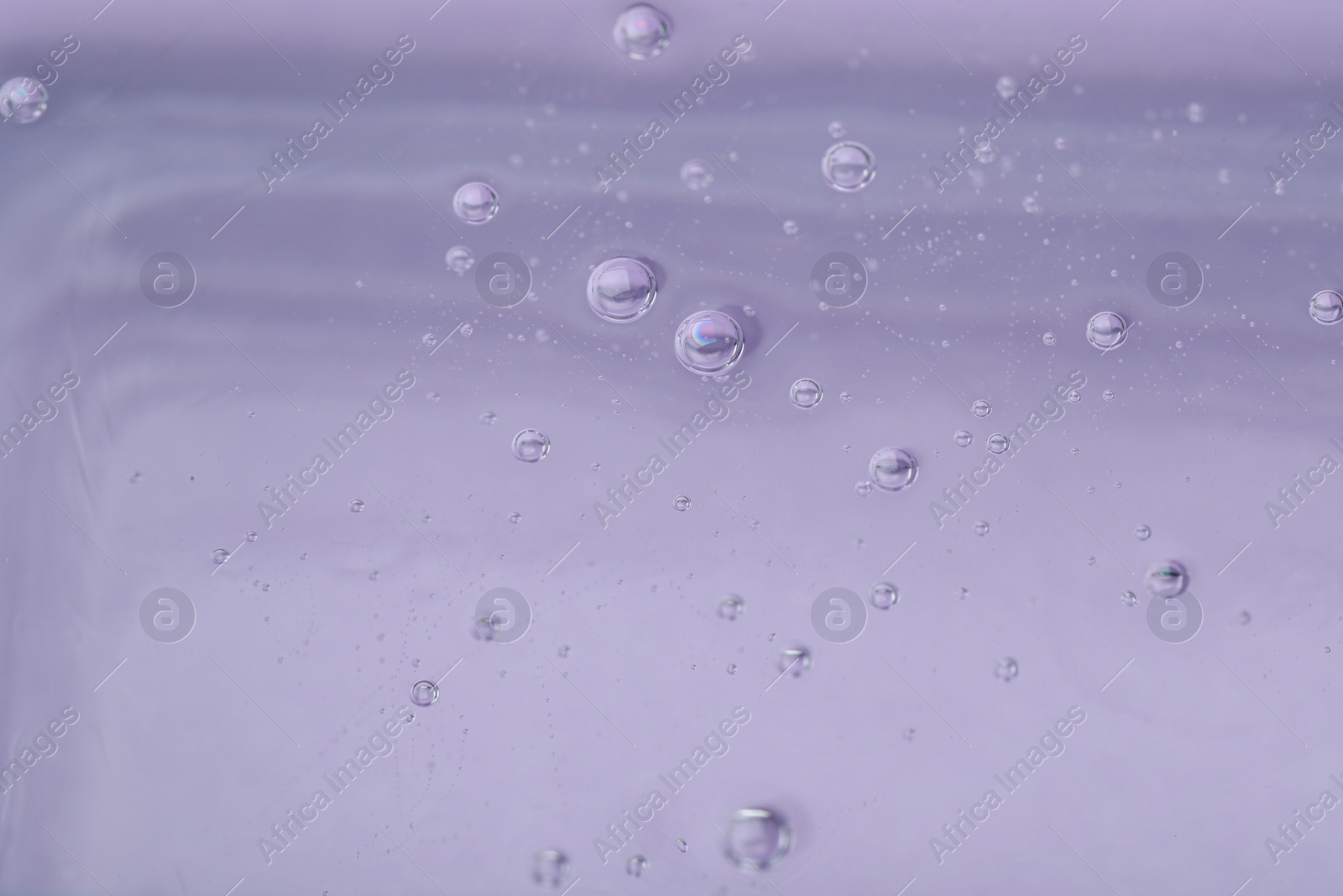 Photo of Pure transparent cosmetic gel on lilac background, closeup