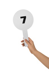 Photo of Woman holding auction paddle with number 7 on white background, closeup