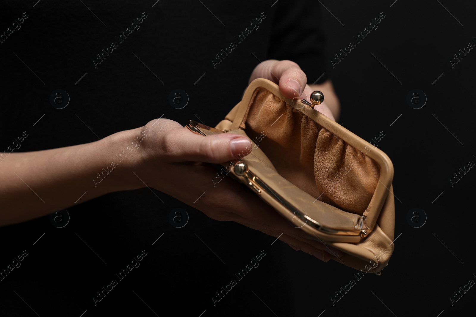 Photo of Woman with empty wallet on black background, closeup