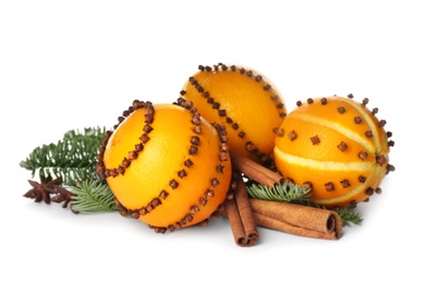 Pomander balls made of fresh oranges and fir tree with spices on white background