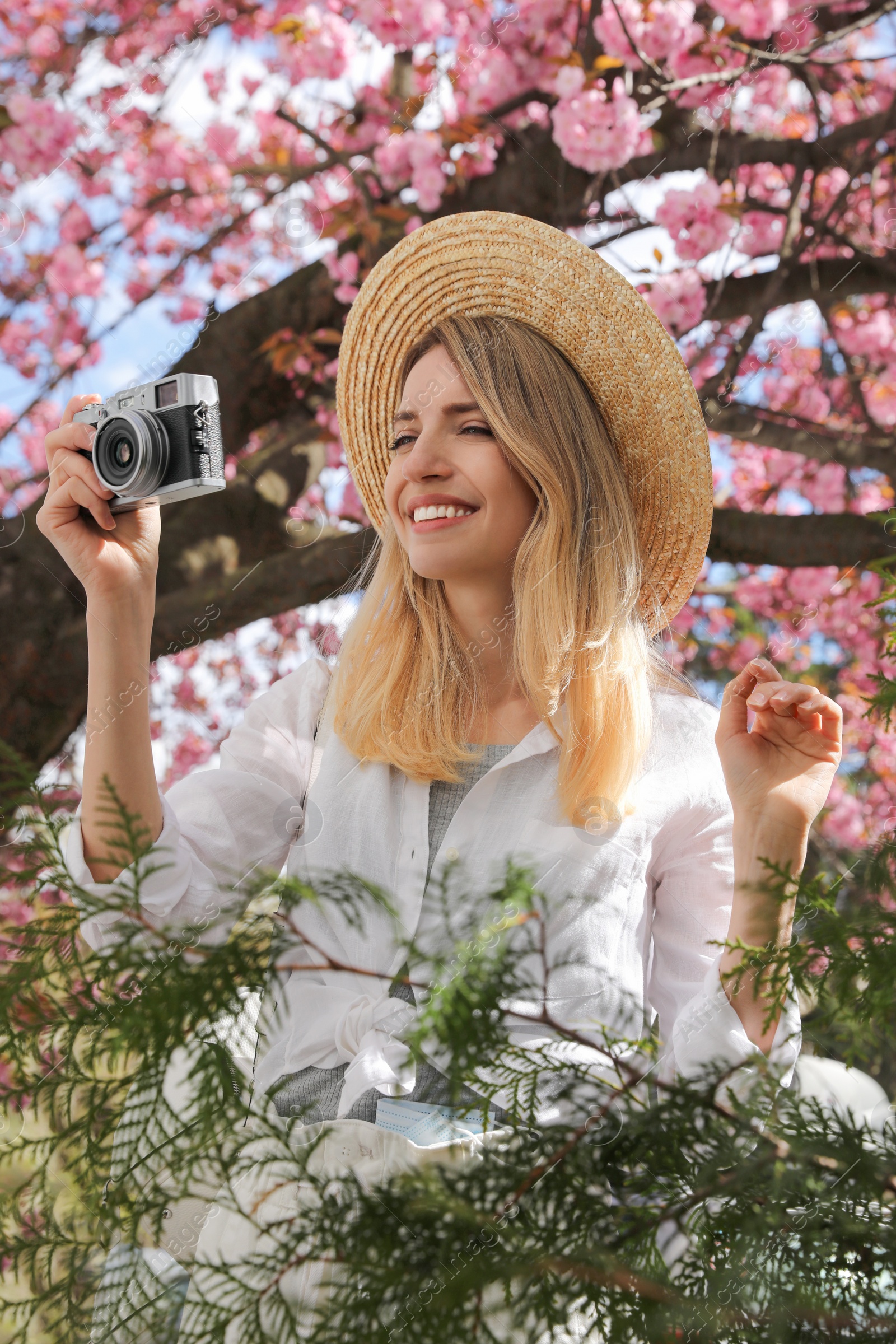 Photo of Happy female tourist with camera outdoors on spring day