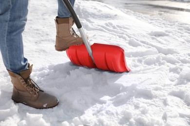 Photo of Person shoveling snow outdoors on winter day, closeup