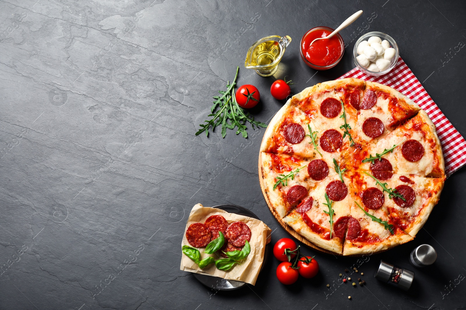 Photo of Flat lay composition with hot pepperoni pizza on dark table. Space for text