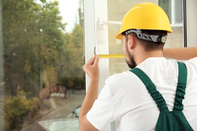 Photo of Construction worker installing new window in house