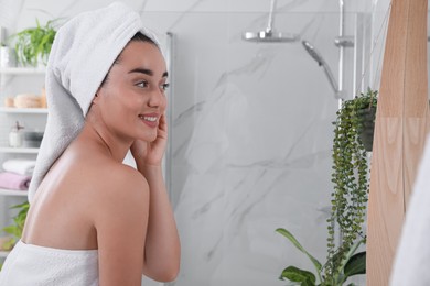 Photo of Beautiful young woman with perfect skin near mirror in bathroom. Facial wash