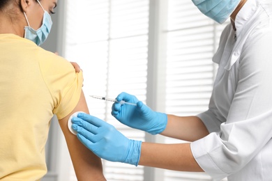 Doctor giving injection to patient in hospital, closeup. Vaccination day