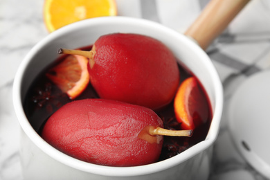 Poaching pears in mulled wine on table, closeup