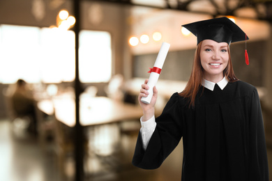 Image of Happy student with graduation hat and diploma in office, space for text