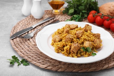 Photo of Delicious rice with chicken served on light grey table, closeup