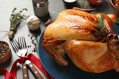 Platter of cooked turkey with rosemary on table, closeup