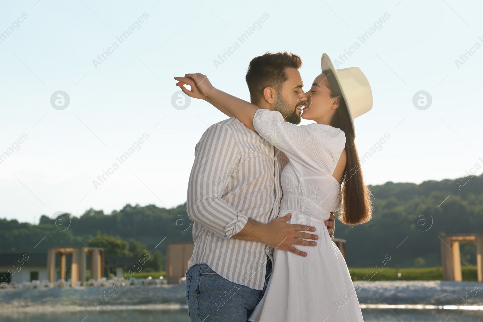 Photo of Romantic date. Beautiful couple kissing on sunny day outdoors
