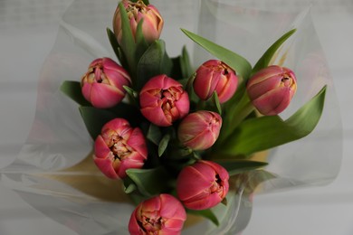 Photo of Beautiful bouquet of tulips on blurred background, top view