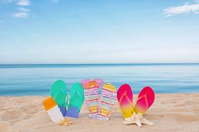 Photo of Sandy beach with different beach accessories near sea. Summer vacation