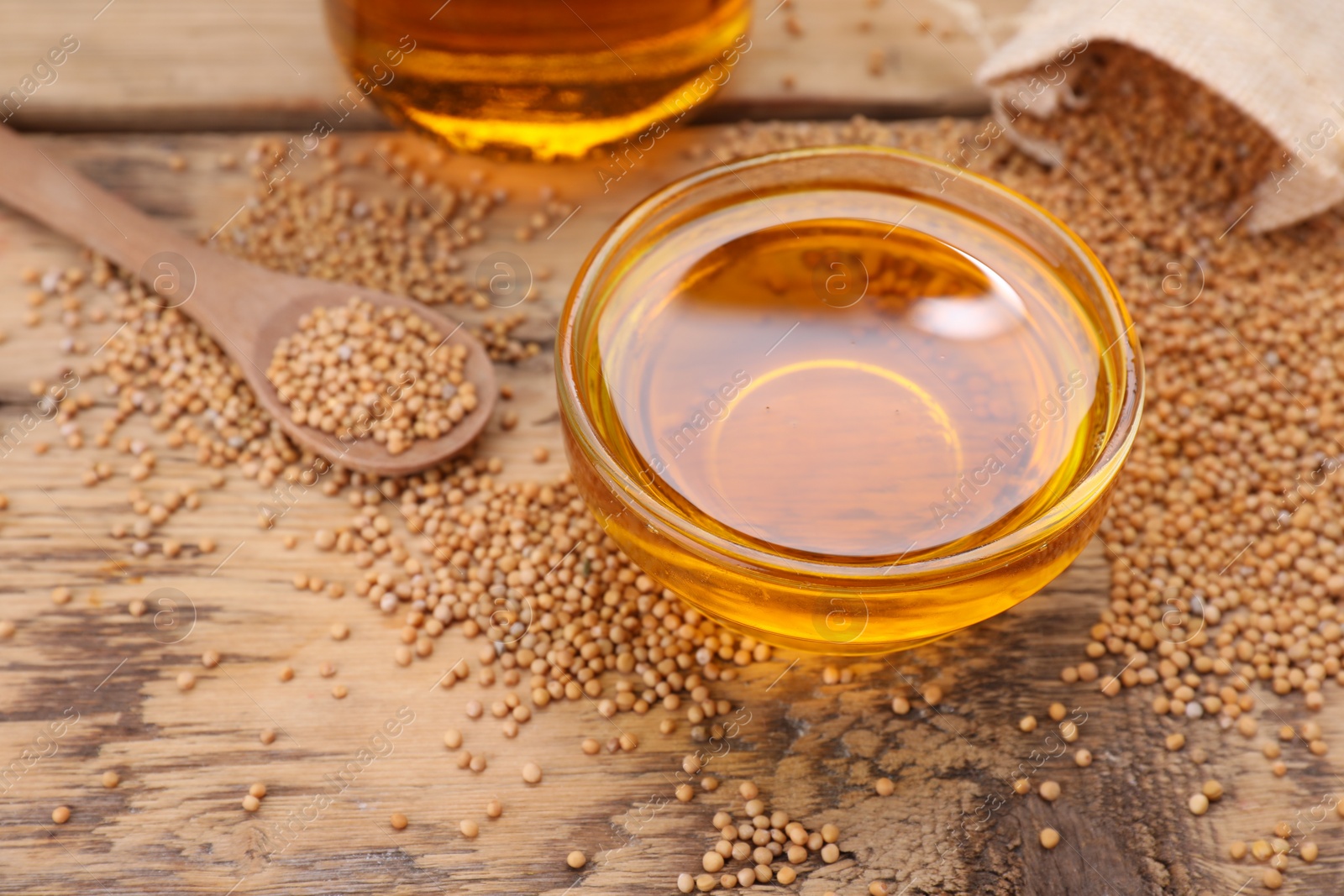 Natural oil and mustard seeds on wooden table. Space for text Photo of Natural oil and mustard seeds on wooden table. Space for text