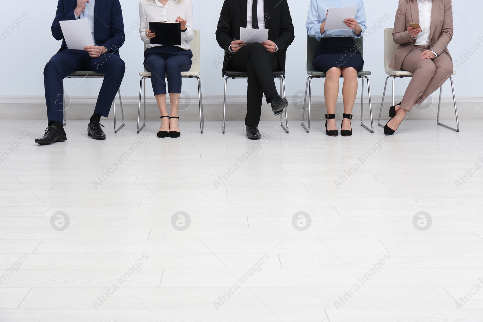 Photo of People waiting for job interview in office hall, closeup