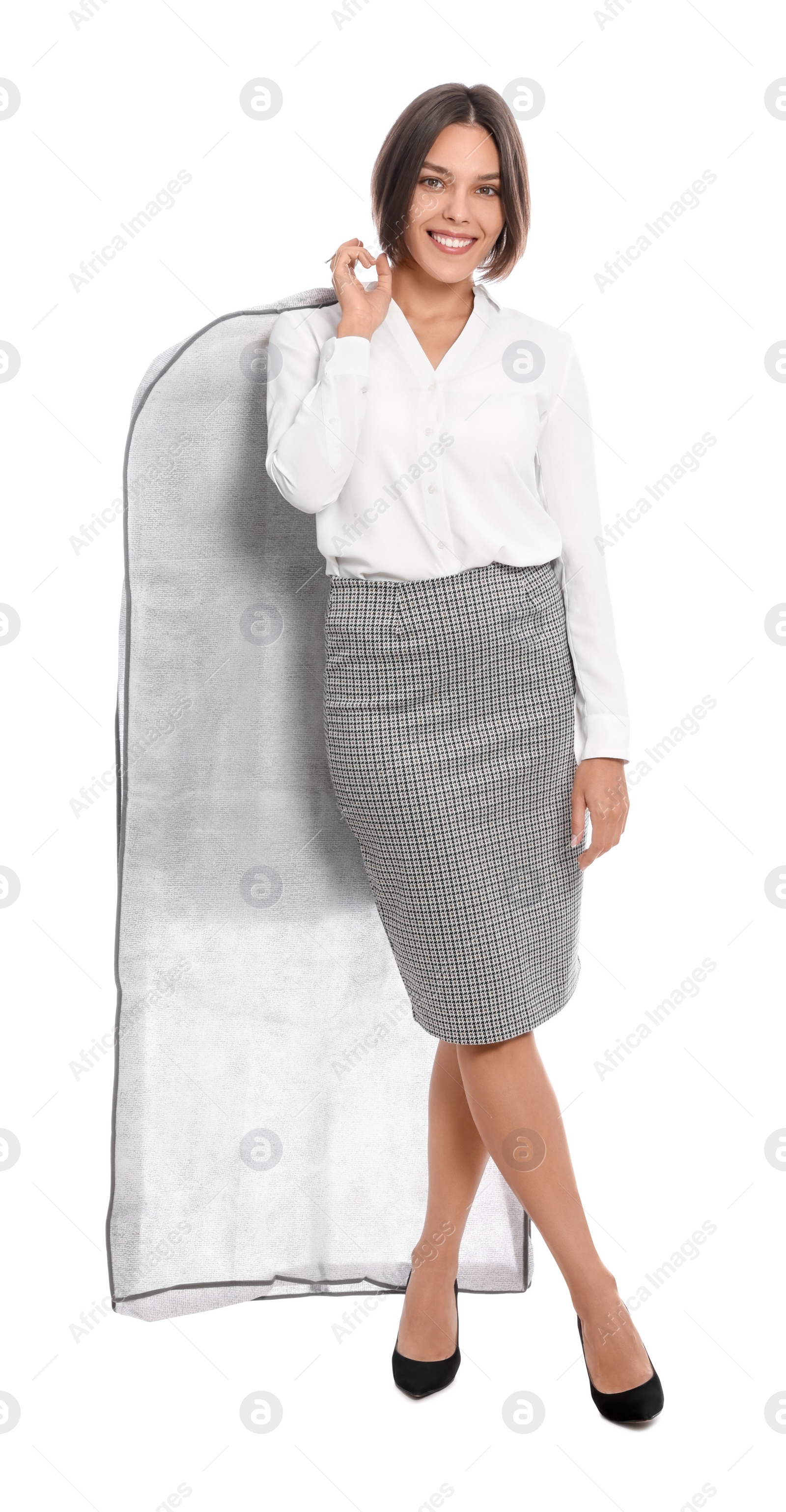 Photo of Woman holding garment cover with clothes on white background. Dry-cleaning service