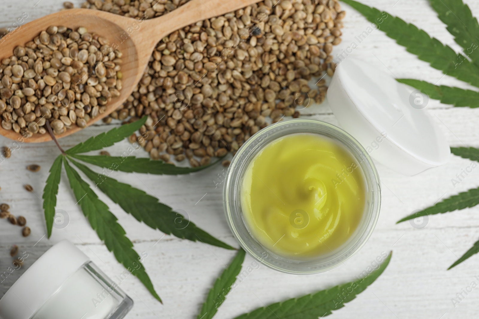 Photo of Flat lay composition with hemp cream on white wooden table. Organic cosmetics