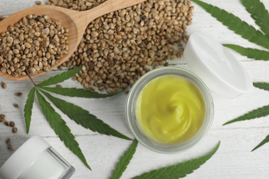 Photo of Flat lay composition with hemp cream on white wooden table. Organic cosmetics