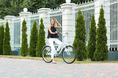 Photo of Beautiful woman in casual outfit with bicycle on city street