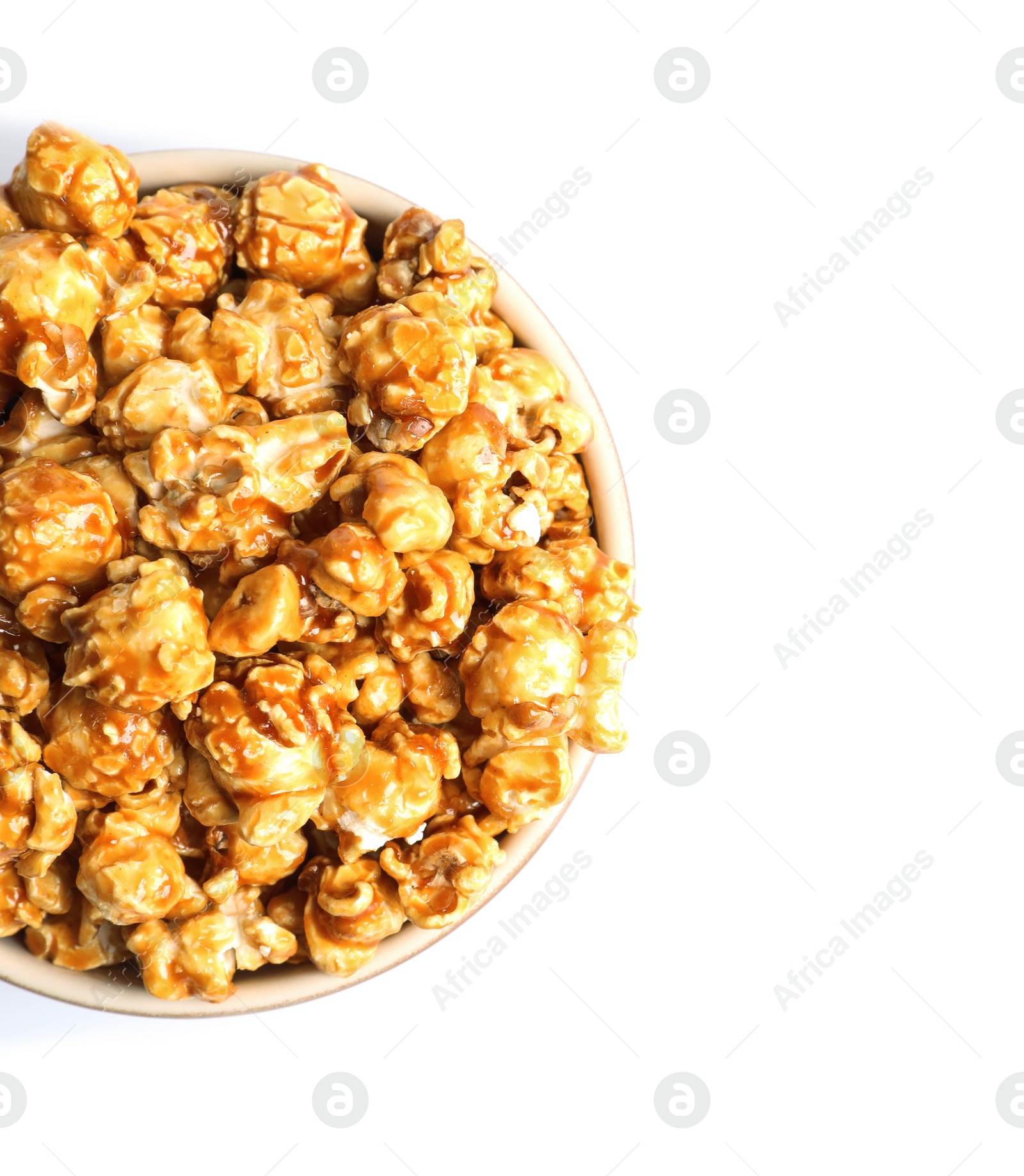 Photo of Delicious popcorn with caramel in bowl on white background