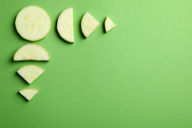 Photo of Fresh ripe cut zucchini on green background, flat lay. Space for text