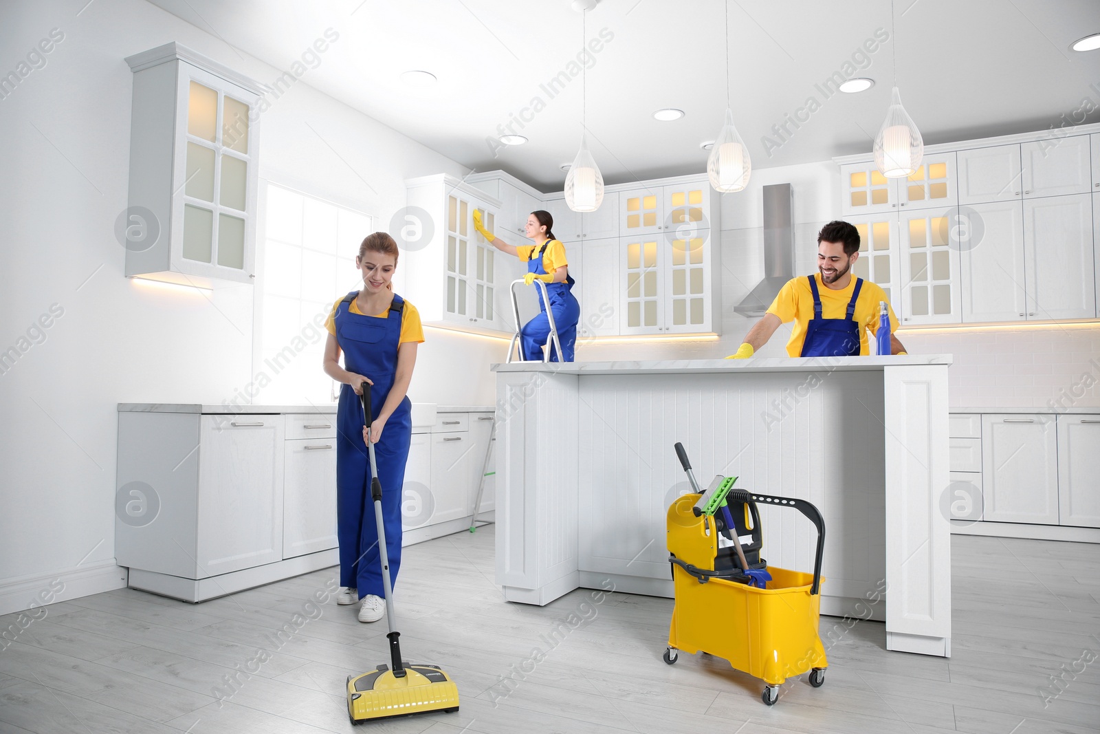 Photo of Team of professional janitors cleaning modern kitchen