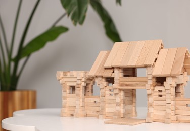 Wooden entry gate on white table against blurred background, space for text. Children's toy