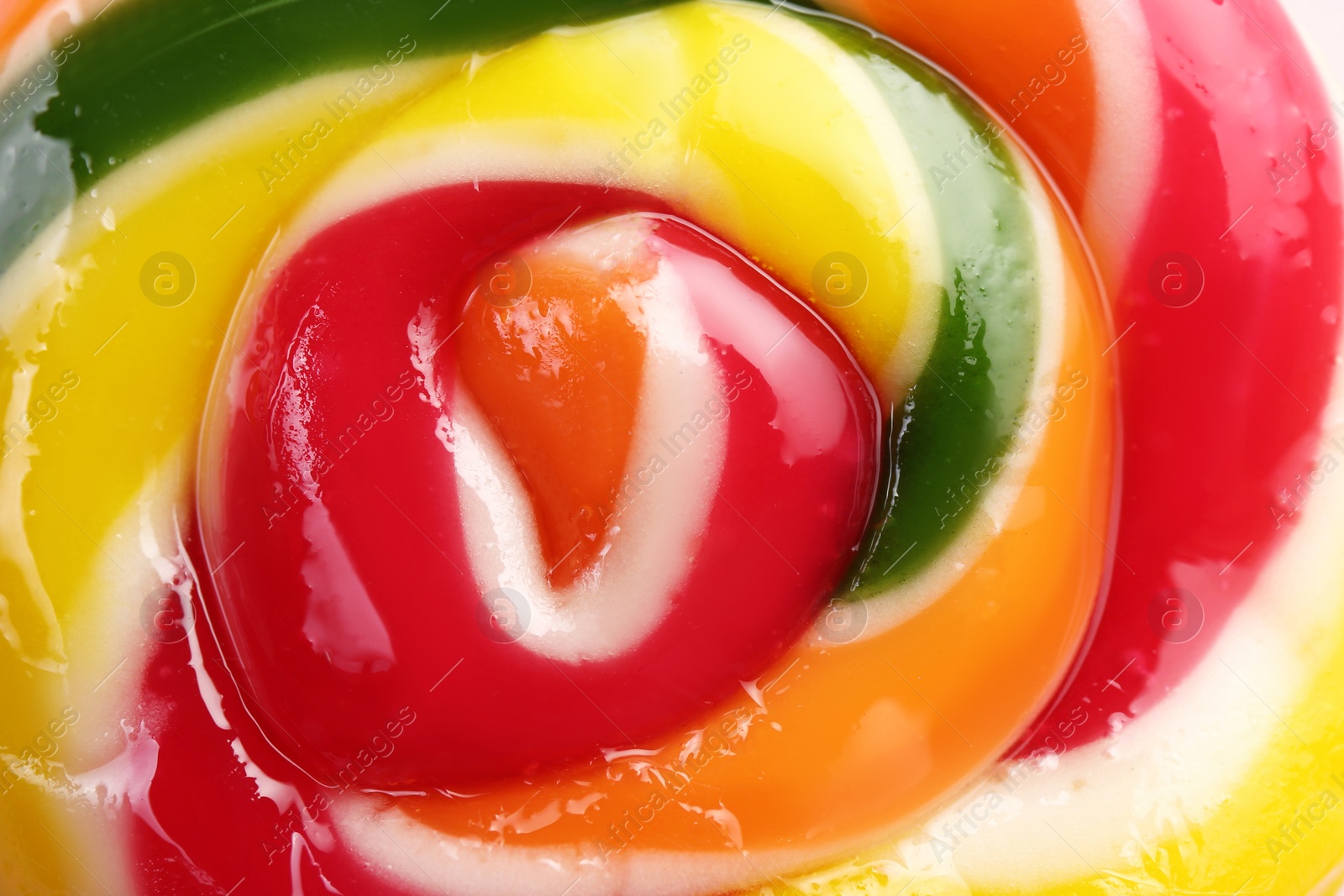 Photo of Sweet colorful lollipop on pink background, closeup view. Delicious candy