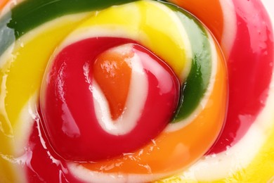 Sweet colorful lollipop on pink background, closeup view. Delicious candy