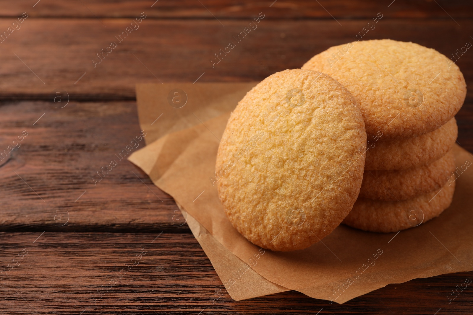 Photo of Delicious Danish butter cookies on wooden table, closeup. Space for text