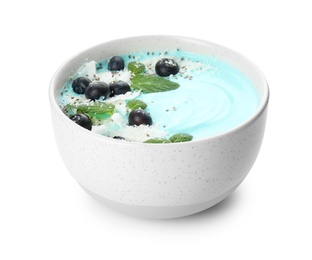 Bowl of spirulina smoothie with coconut, blueberries and chia seeds isolated on white