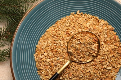 Photo of Plate with dried orange seasoning zest on beige textured table, top view