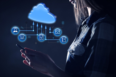 Image of Cloud computing and storage concept. Woman using smartphone on dark background, closeup