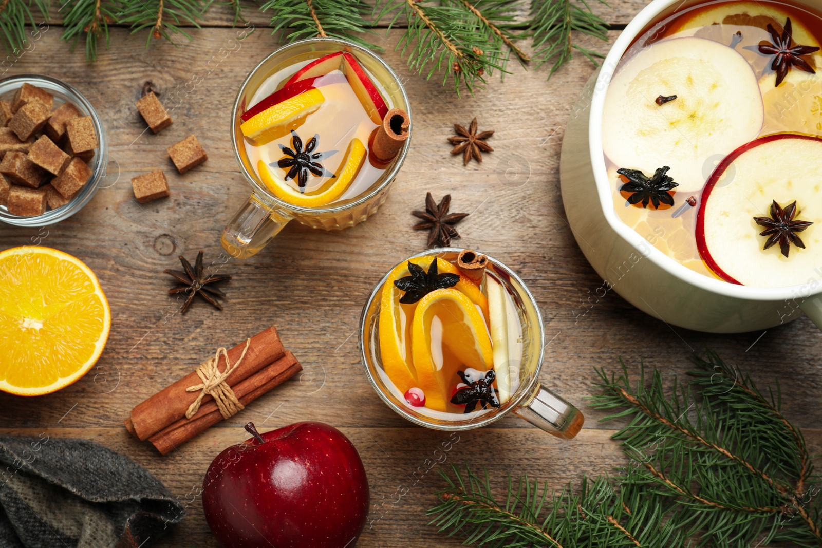 Photo of Aromatic mulled wine on wooden table, flat lay