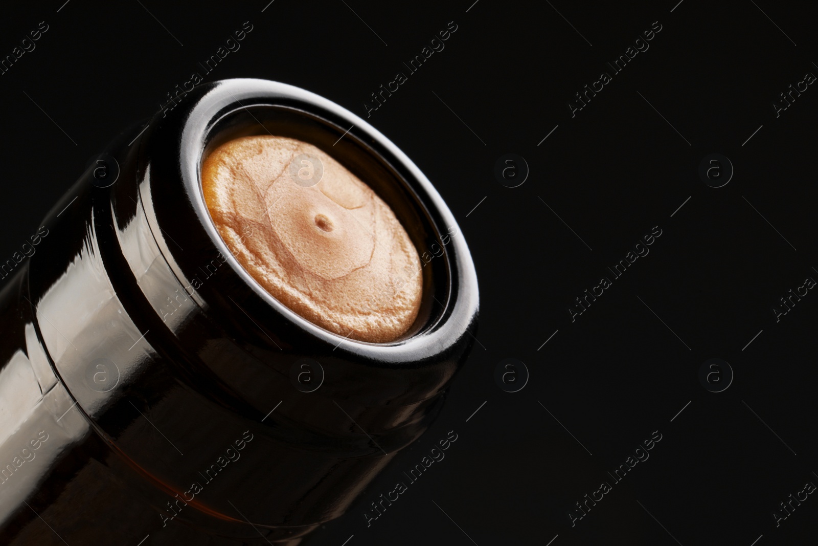 Photo of Wine bottle with cork on black background, closeup. Space for text