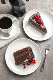 Slices of tasty chocolate cake and cup of coffee served on table, top view