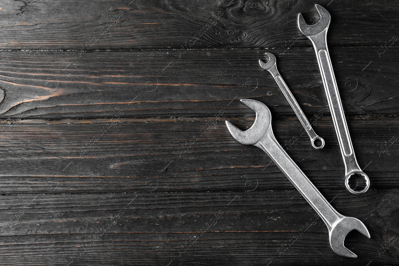 Photo of New wrenches on wooden background, top view with space for text. Plumber tools